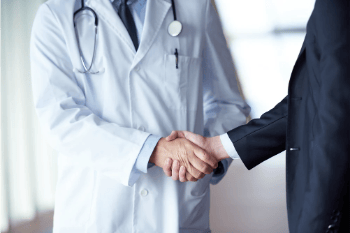 doctor handshake with a patient at doctors bright modern office in hospital (1)