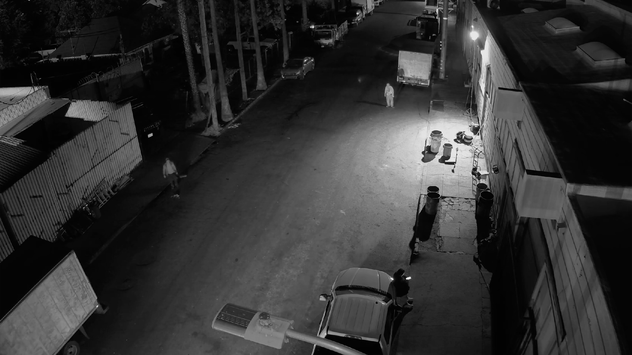 Covert camera view of a telecom site at night with suspects on the street